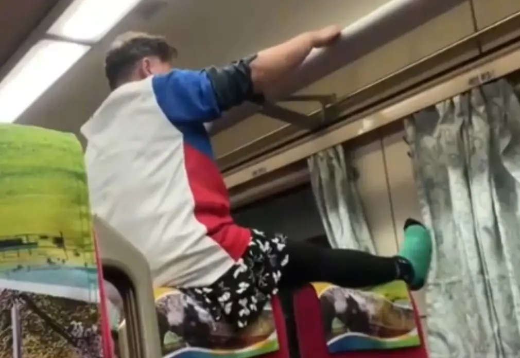 ▲張姓女乘客於台鐵521次莒光號上，將雙手吊掛於置物架上，不斷晃動「拉筋」更將雙腿放置於窗戶上，引發其他乘客不滿，過程被拍攝下來PO網。（圖／翻攝畫面）