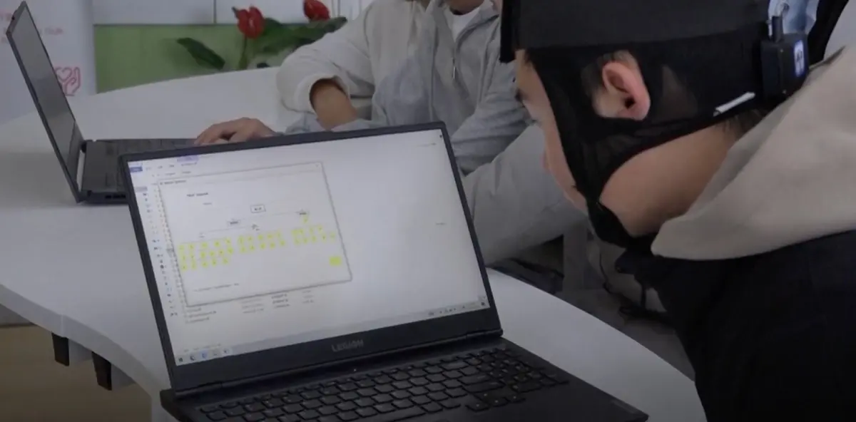 ▲中國長春理工大學一名學生與研究團隊耗時兩年，研發出能夠擷取大腦電波訊息並轉換成文字的穿戴裝置。（圖／美聯社／達志影像）