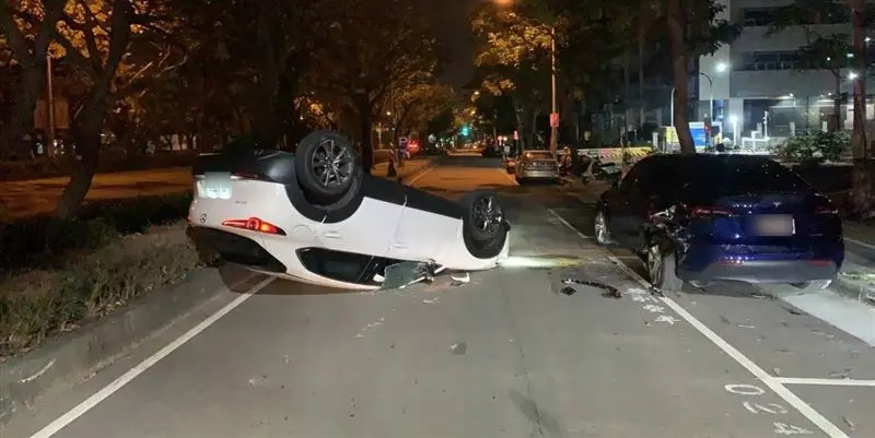 ▲黃女撞上路邊車輛後翻覆路中。（圖／翻攝畫面）