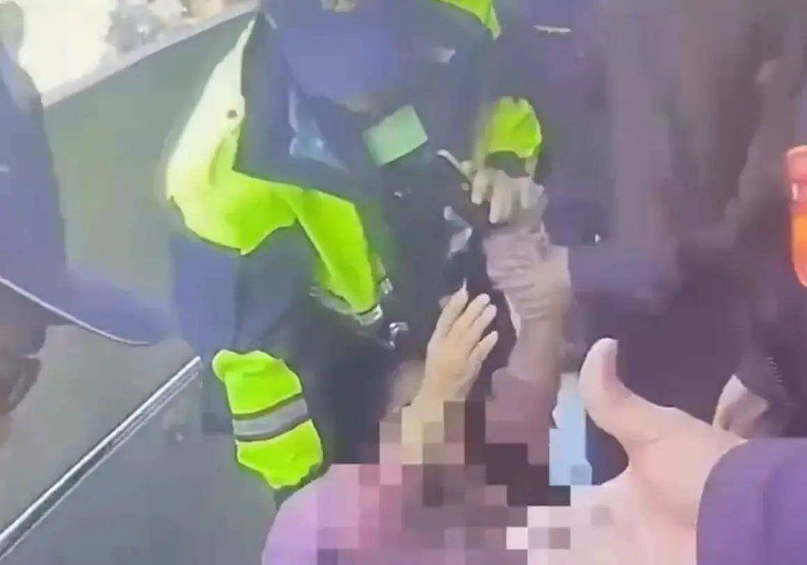 ▲李女遭警方強制拖離30公尺。（圖／翻攝畫面）