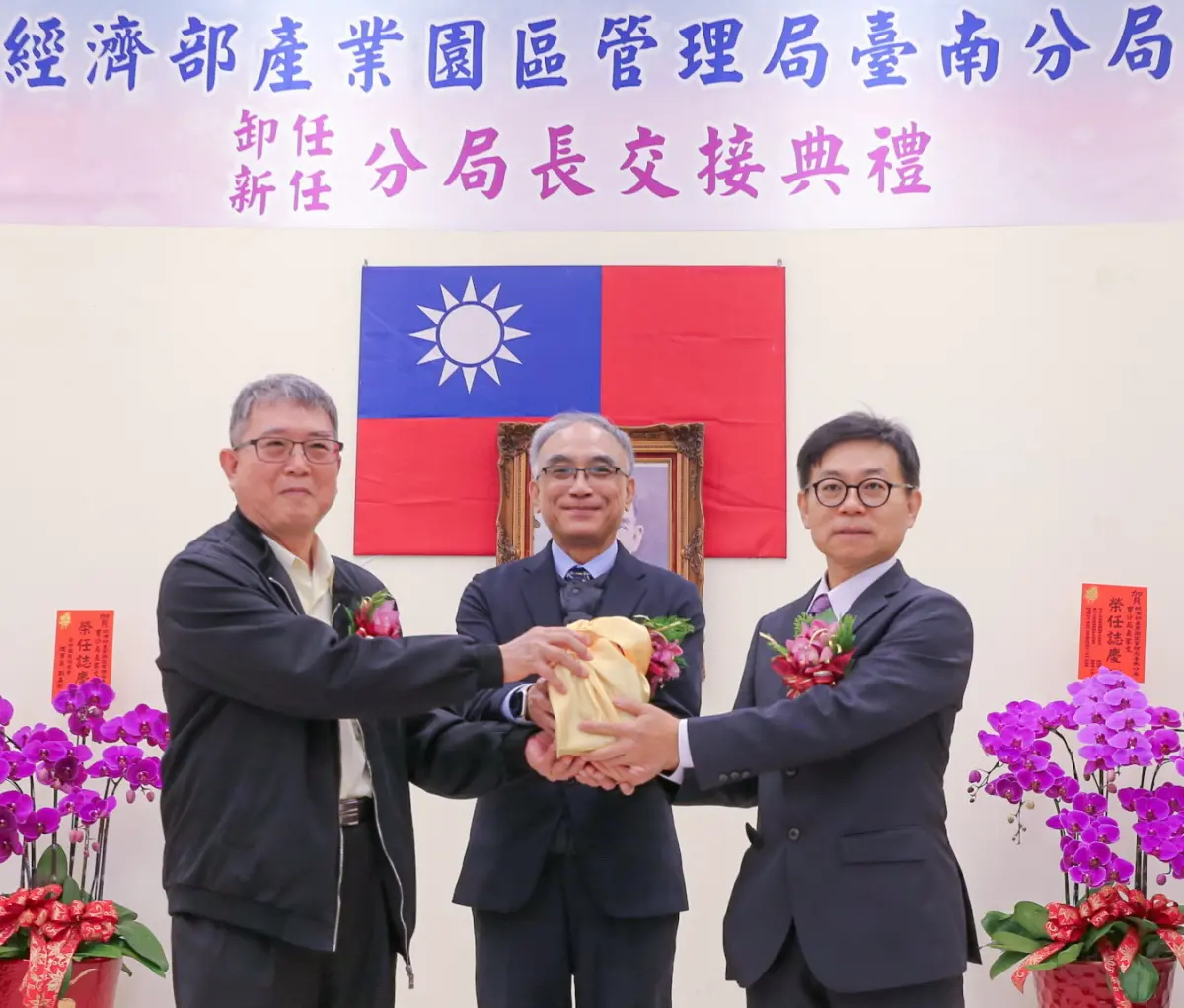 ▲經濟部產業園區管理局舉行台南分局新卸任分局長交接儀式，卸任分局長沈龍志(左)，在局長楊伯耕(中)監交下，將印信交給新任分局長曹家文(右)完成交接。(圖／產業園區管理局提供)