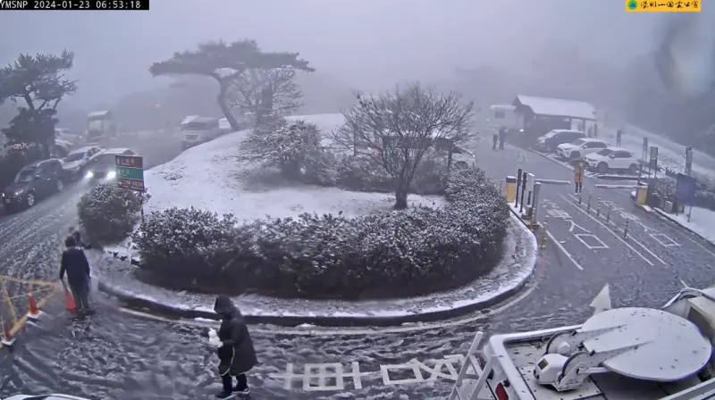 ▲寒流發威下雪了！今日上午近7時，從二子坪停車場的即時影像可以看到不少人開始追雪，還有民眾手捧著「小雪人」。（圖／翻攝畫面）