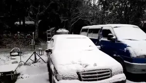 ▲烏來山區的967高地下起雪來，停放的車輛被白雪覆蓋，附近空地也布滿白雪，變身為銀白世界。（圖 ／新店警分局提供）