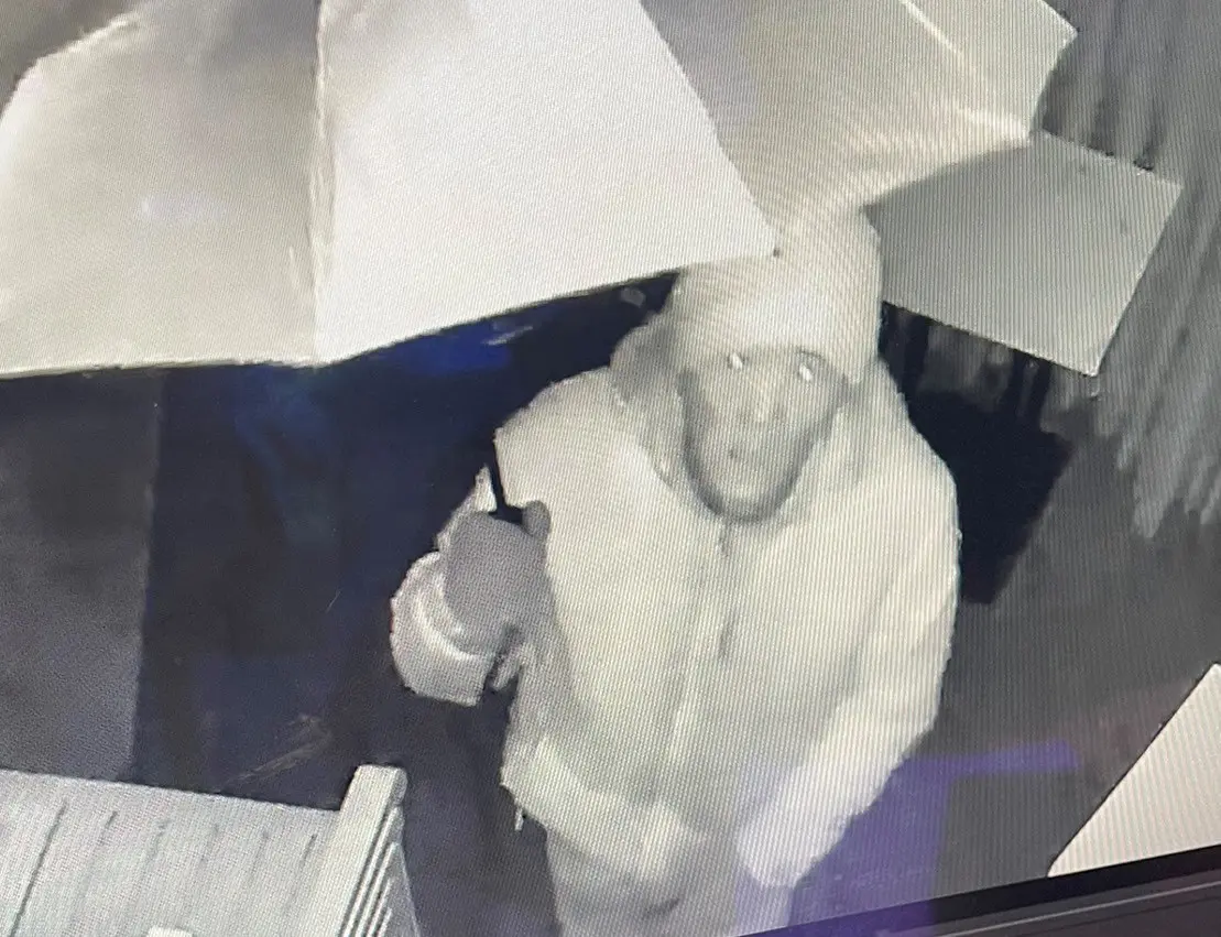 ▲小偷行竊時還撐開一把傘，企圖閃避監視鏡頭，但還是不小心被拍到臉部長相（圖/記者鄧力軍翻攝）