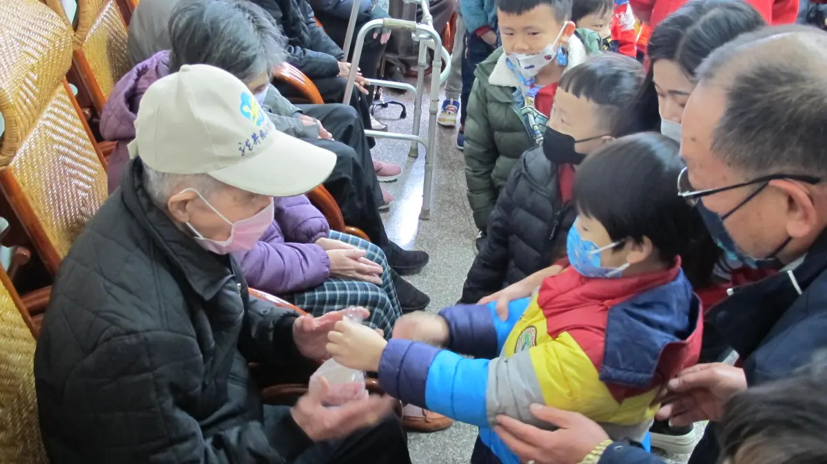 ▲龍井幼兒園50幼兒，年前帶著發糕探訪龍井多元照顧中心長輩，小朋友親手送上發糕，老人樂開懷。（圖／龍井多元照顧中心提供）