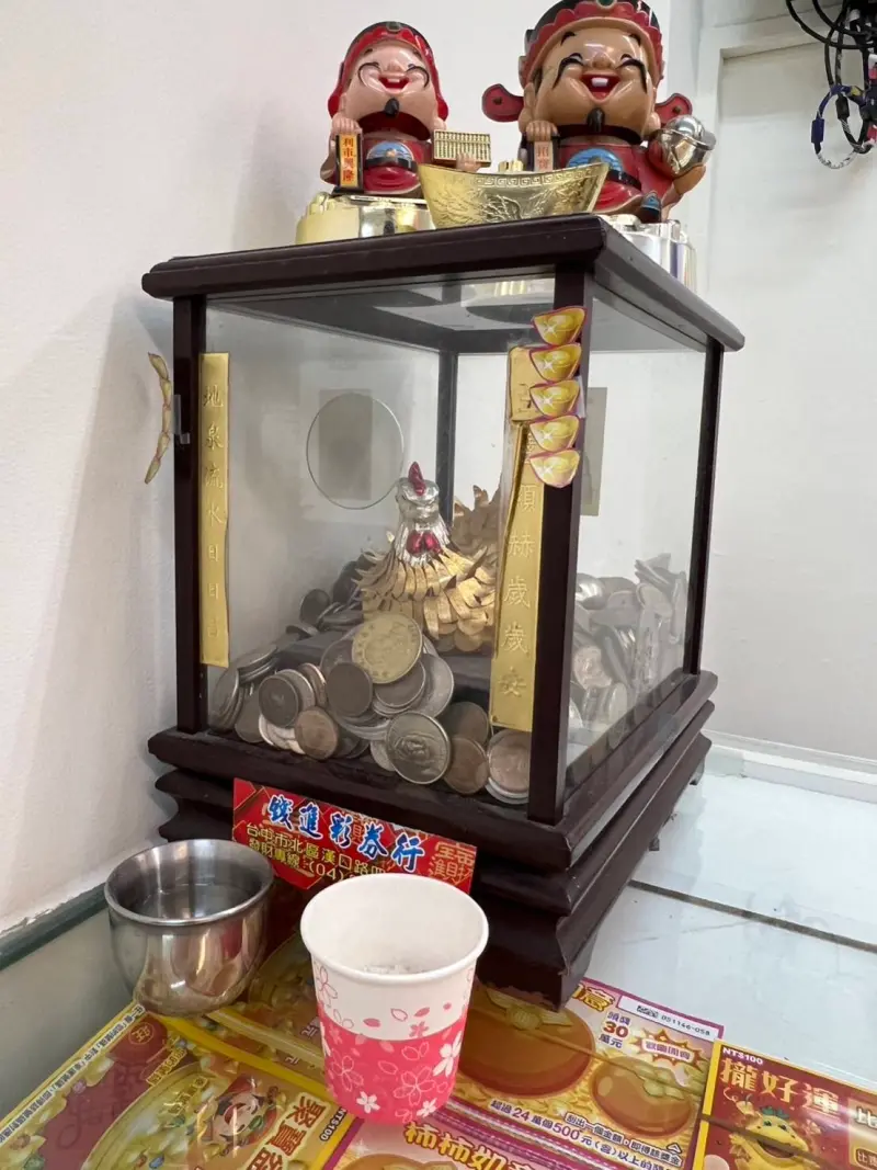 ▲彩券行供奉「金雞」,並直接擺在櫃檯,客人有中獎,也愛往裡面丟些零錢,分享喜氣。(圖/台灣彩券提供)