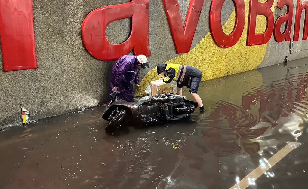 ▲板橋一名女騎士誤闖封閉的積水地下道不慎自摔，巡邏員警見狀趕緊馳援。（圖／翻攝畫面）