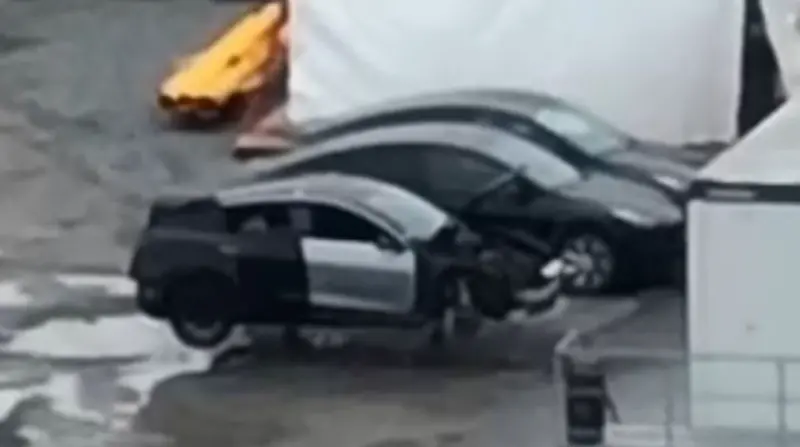 ▲2月15日在Tesla 柏林超級工廠的航拍畫面，其中一段畫面在停車場拍到一輛貼滿偽裝貼紙的未完成車輛，與停放在一旁的 Model Y 對比明顯小上一號。（圖／取自YouTube「Tobias Lindh」）