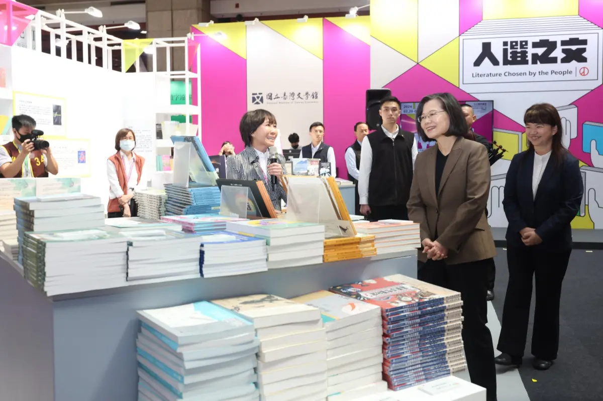 ▲總統蔡英文（右二）任內最後一次逛書展，看到臺詩兒童繪本《貓奴容鼾睡》，讓愛貓的她會心一笑。（圖／文化部提供）