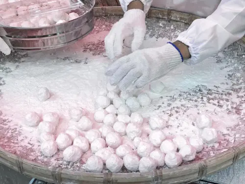 ▲元宵的做法是將餡料放入有糯米乾粉的竹篩中慢慢「搖」出來的。（圖／取自新光三越南西店臉書）