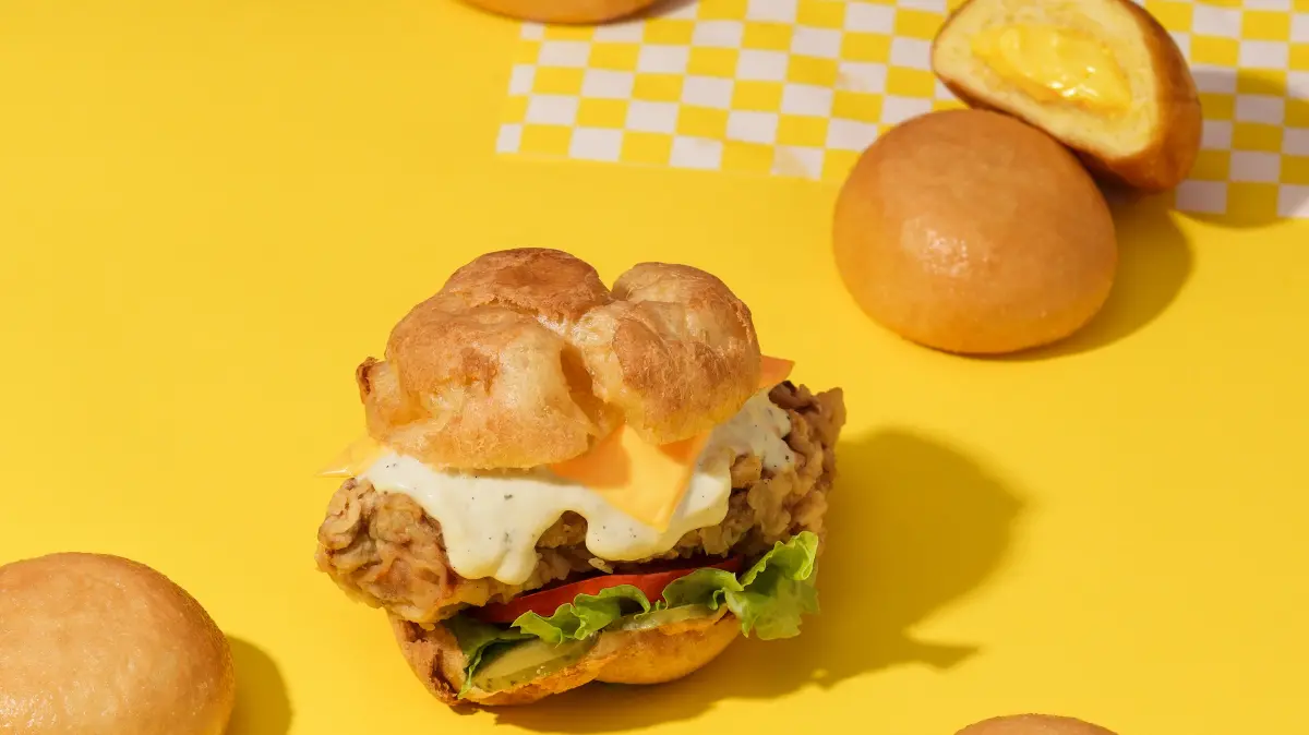 ▲頂呱呱聯名日本泡芙爺爺beard papa's，搭配爆漿卡士達內餡，讓甜甜包「不再是小廢包」！還有田園卡士達炸雞泡芙堡。肯德基也開賣黃金魚子海陸Q蝦堡、莫札瑞拉起司球。（圖／頂呱呱提供）