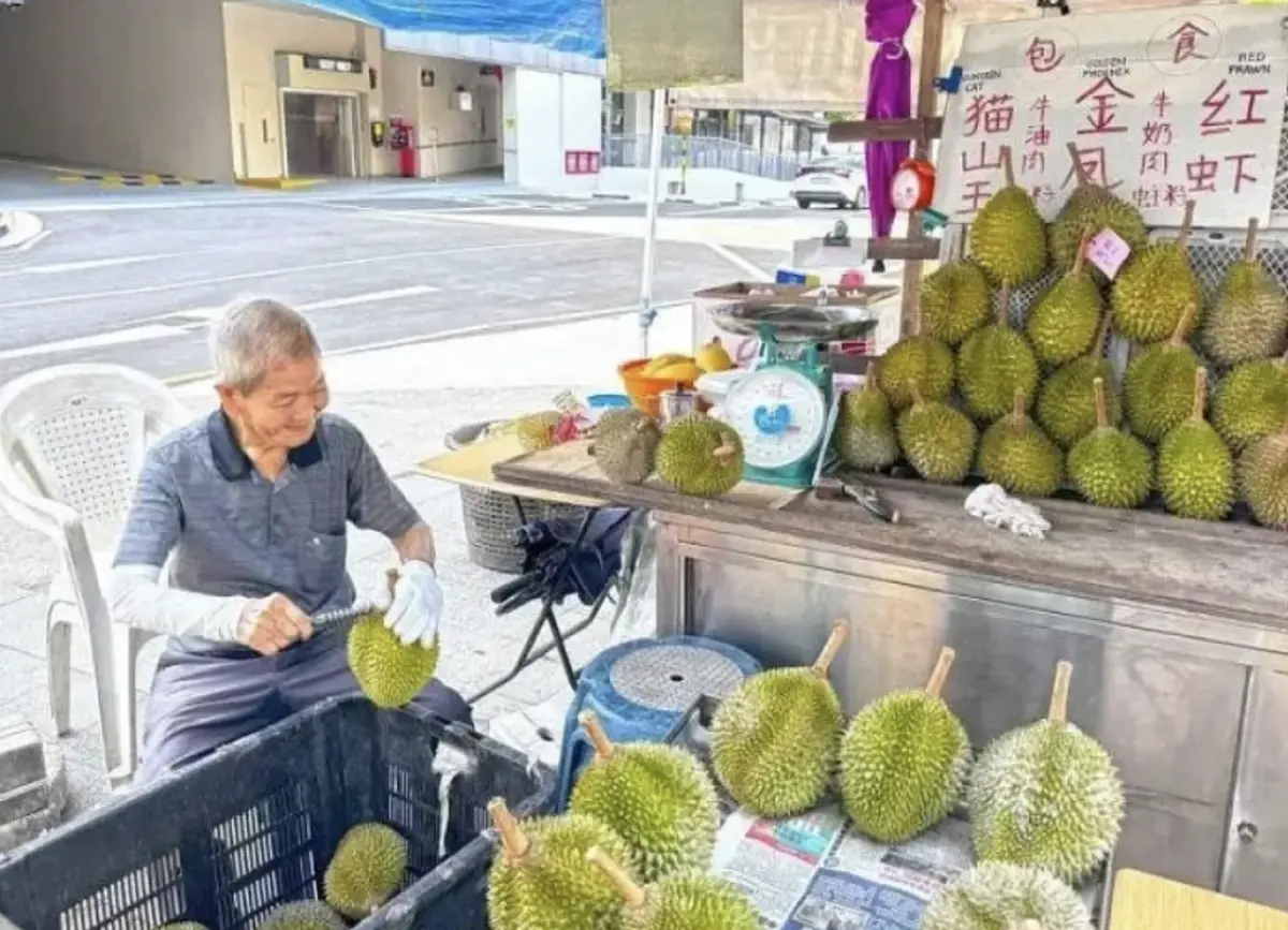 ▲新加坡一位91歲的老爺爺張文德，已經擺攤賣榴槤逾60年，即使現在年紀大了，仍每天上工。（圖／翻攝自新明日報）