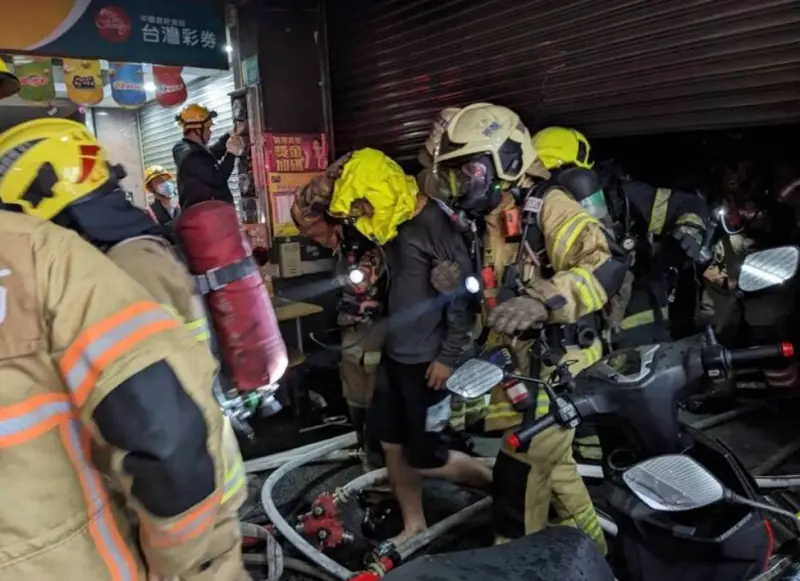 ▲8日晚間10時許，台南永康區中正北路某彩券行發生火警，消防人員於2樓、4樓各救出受困男子。（圖／翻攝畫面）