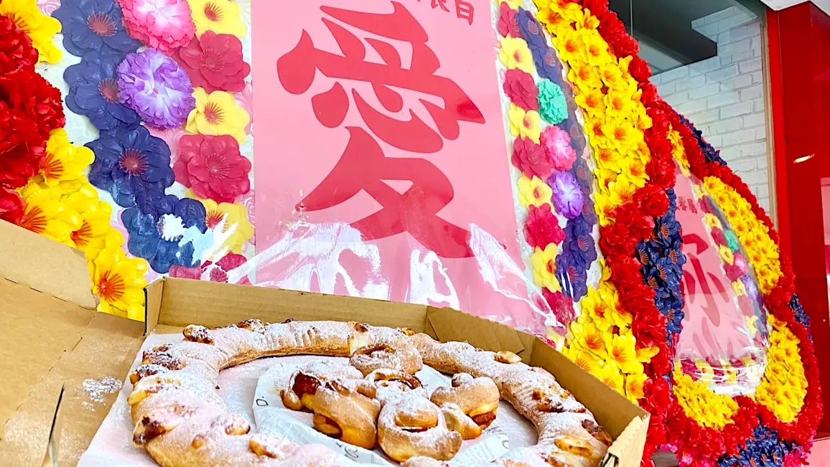 ▲3月14日白色情人節必勝客獵奇打造「粉愛你花圈披薩」，玫瑰花包覆美式臘腸，搭配「粉紅熔岩芝心圈圈」，優惠199元快閃開賣7天。台北小巨蛋的敦化門市豎起「婚喪喜慶花圈」告白愛你。（圖／必勝客提供）