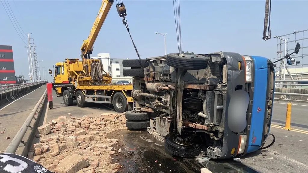 ▲丁男駕駛貨車行經竹湖陸橋時，不明原因擦撞護爛，導致車輛失控翻覆。（圖／翻攝畫面）