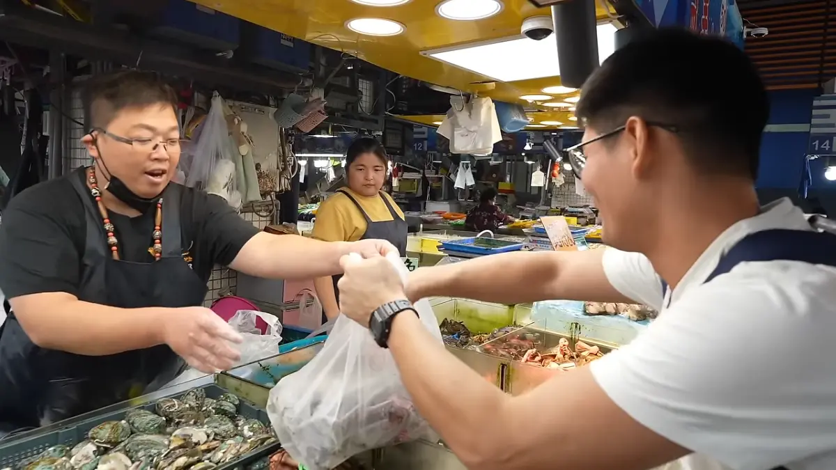 ▲小鐘被高雄老闆熱情所折服，買了一大包海鮮「結帳金額3位數」，連在地人看了都驚訝。（圖／取自Youtube頻道「小鐘Johnny」）