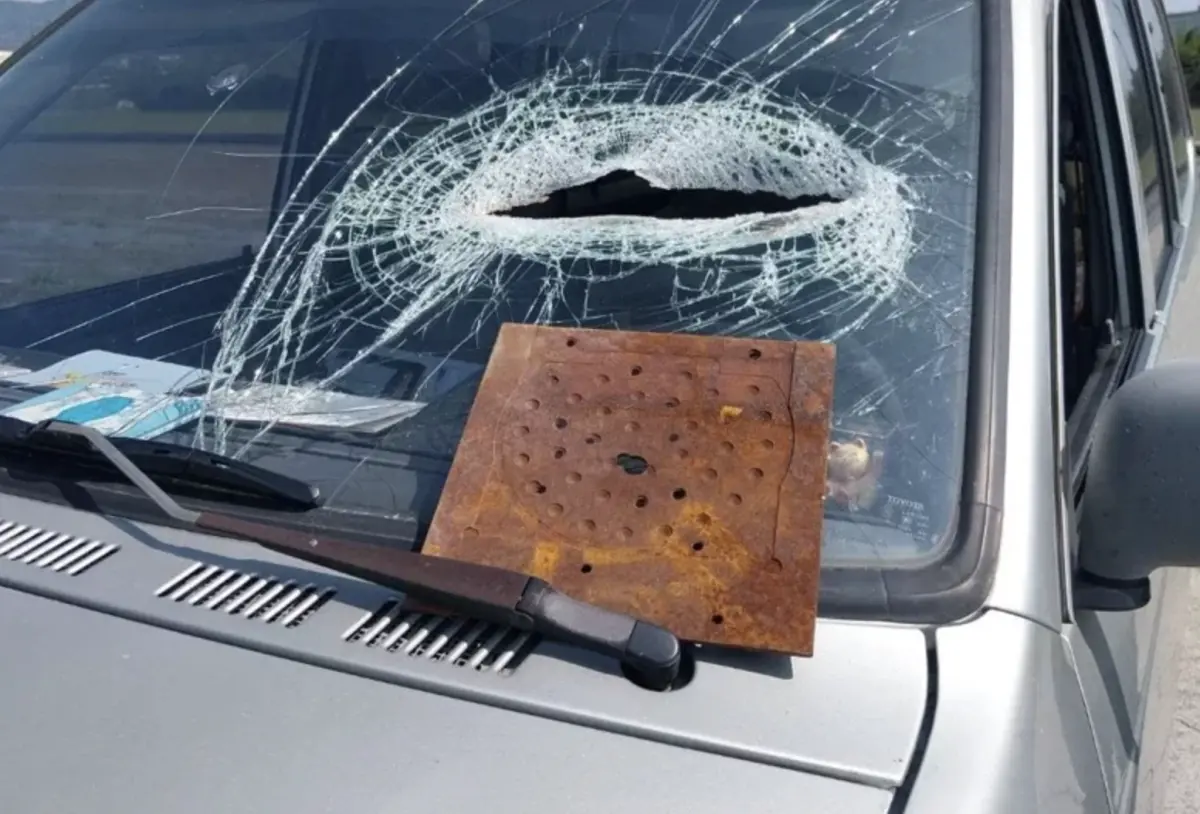 ▲台中一名陳姓女子今（19）日下午開車，行經苗栗縣苑裡鎮田心里苗140線裕芳食品前，突然天外飛來一塊鐵片，當場砸中擋風玻璃，導致擋風玻璃碎裂，造成陳女下巴及四肢受傷送醫。（圖／翻攝畫面）