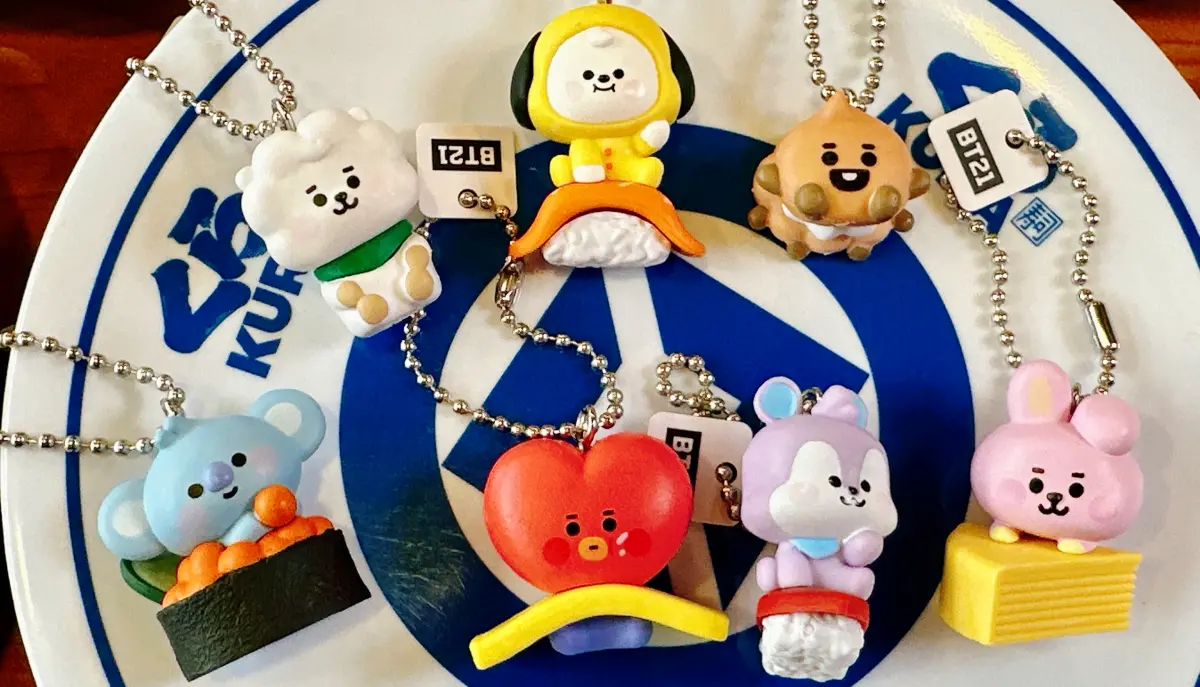 ▲藏壽司聯名宇宙明星BT21扭蛋15款，一次整理KOYA、CHIMMY、TATA等角色立體吊飾、壓克力吊飾及橡皮擦，3月29日限定開扭。爭鮮提早開賣愚人節「飯裡藏鮮」白飯便當。（圖／藏壽司提供）
