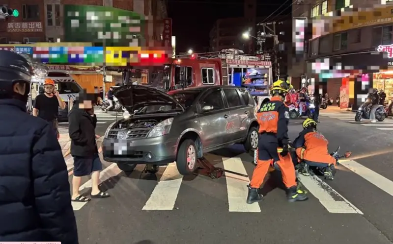 ▲22日晚間，新北市蘆洲區民族、復興路口，發生車禍事故，一台自小客車與機車發生擦撞，陳姓騎士當場被捲入車底，被緊急送往北市新光醫院搶救。（圖／翻攝畫面）