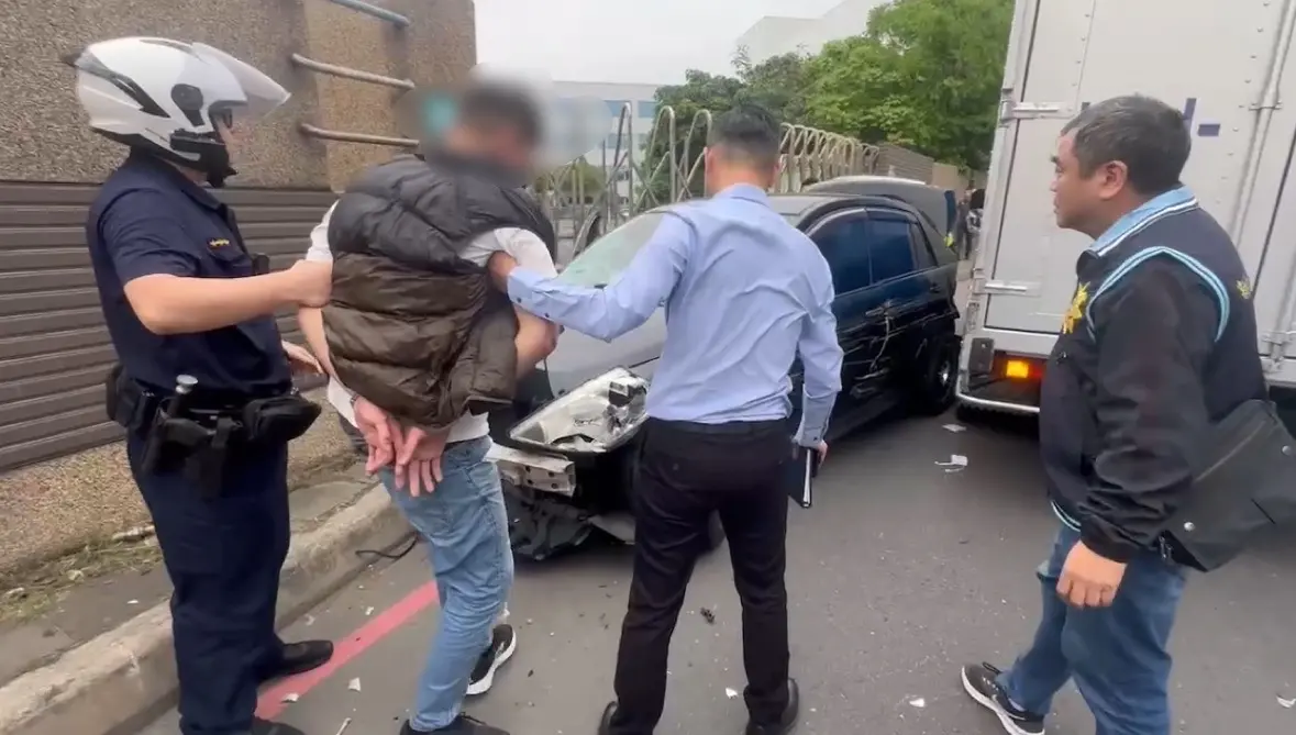 ▲新北市新莊丹鳳派出所員警圍捕詐欺車手，犯嫌駕車行駛到新北大道、中華路口停等紅燈的時候，遭到員警上前圍捕，犯嫌為避免逃脫開車衝撞員警，警方見狀連開7槍回擊。（圖／翻攝畫面）