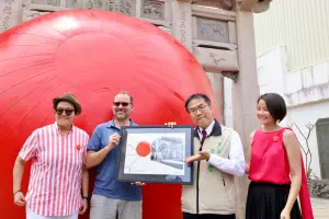 ▲紅球計畫藝術家Kurt Perschke特別贈送給黃偉哲一幅親自繪製的畫，表達了他初次來臺南勘景時的印象，並在上面留言感謝南市府對紅球計畫的支持。（圖／台南市府提供）