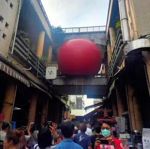 ▲紅球計畫今天將巨大紅球巡迴到永樂市場，引來大批民眾。（圖／翻攝爆料公社）