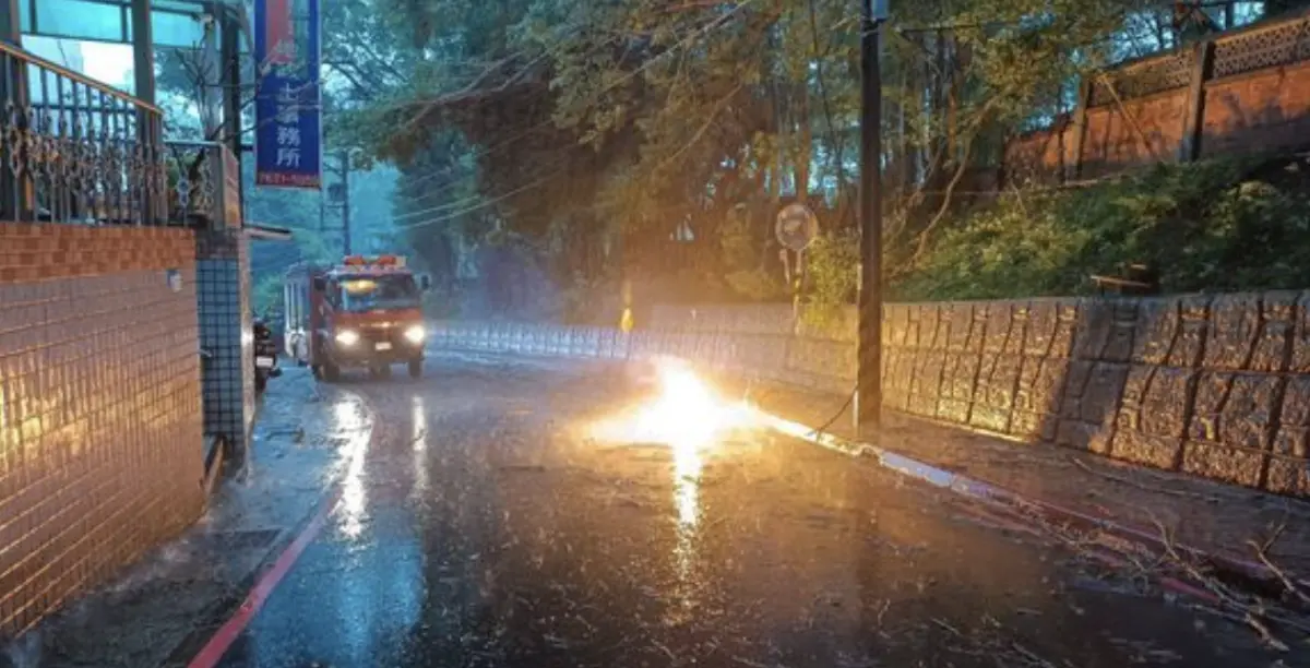 ▲淡水下午下起大雨，新民街210號對面電線掉落短路造成大停電。（圖／翻攝畫面）