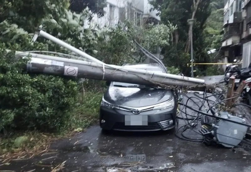 ▲士林區中社路今天下午發生電桿倒塌案件，當場壓毀一輛轎車，消防局獲報到場查看，幸未釀傷亡。（圖／翻攝畫面）