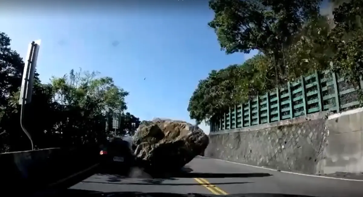 ▲一名駕駛從蘇花改出口往花蓮前進，行駛到半路發現前車車速漸緩，接著地面劇烈搖晃，前車火速倒退，豈料「巨石」從天滾落，該車車尾砸中當場凹陷。（圖／翻攝記者爆料網）