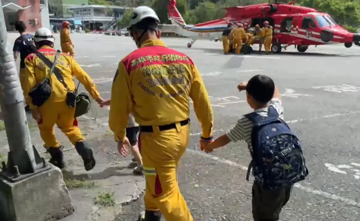 ▲晶英酒店中午執行撤離作業，民眾搭直升機離開，小朋友面對強震後堅強面對，並與搜救人員「大手拉小手」離開，畫面相當感人。（圖／翻攝畫面）