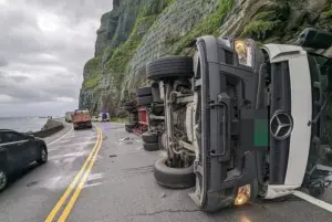 ▲大貨車不明原因翻覆，還擦撞2輛轎車，其中一輛賓士轎車還被夾在車與山壁之間。（圖／翻攝畫面）