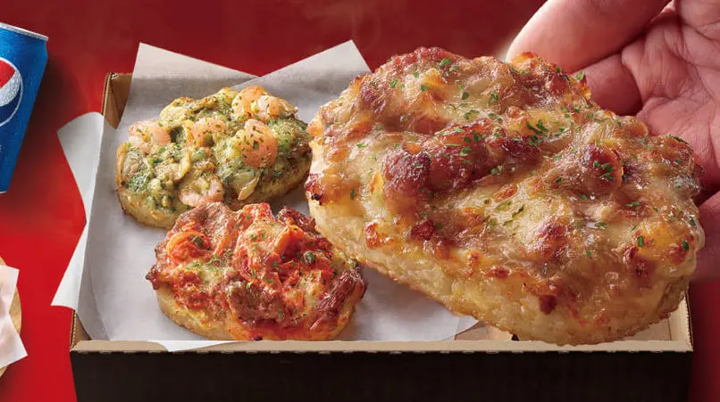 ▲最愛玩食物的必勝客果然瘋了！繼草仔龜、蛇圈圈後，不烤披薩改賣「起司飯糰」了，創新推出起司飯圈圈，還把「霸王功夫雞」打造成炸雞桶，要跟肯德基拚了。（圖／必勝客提供）