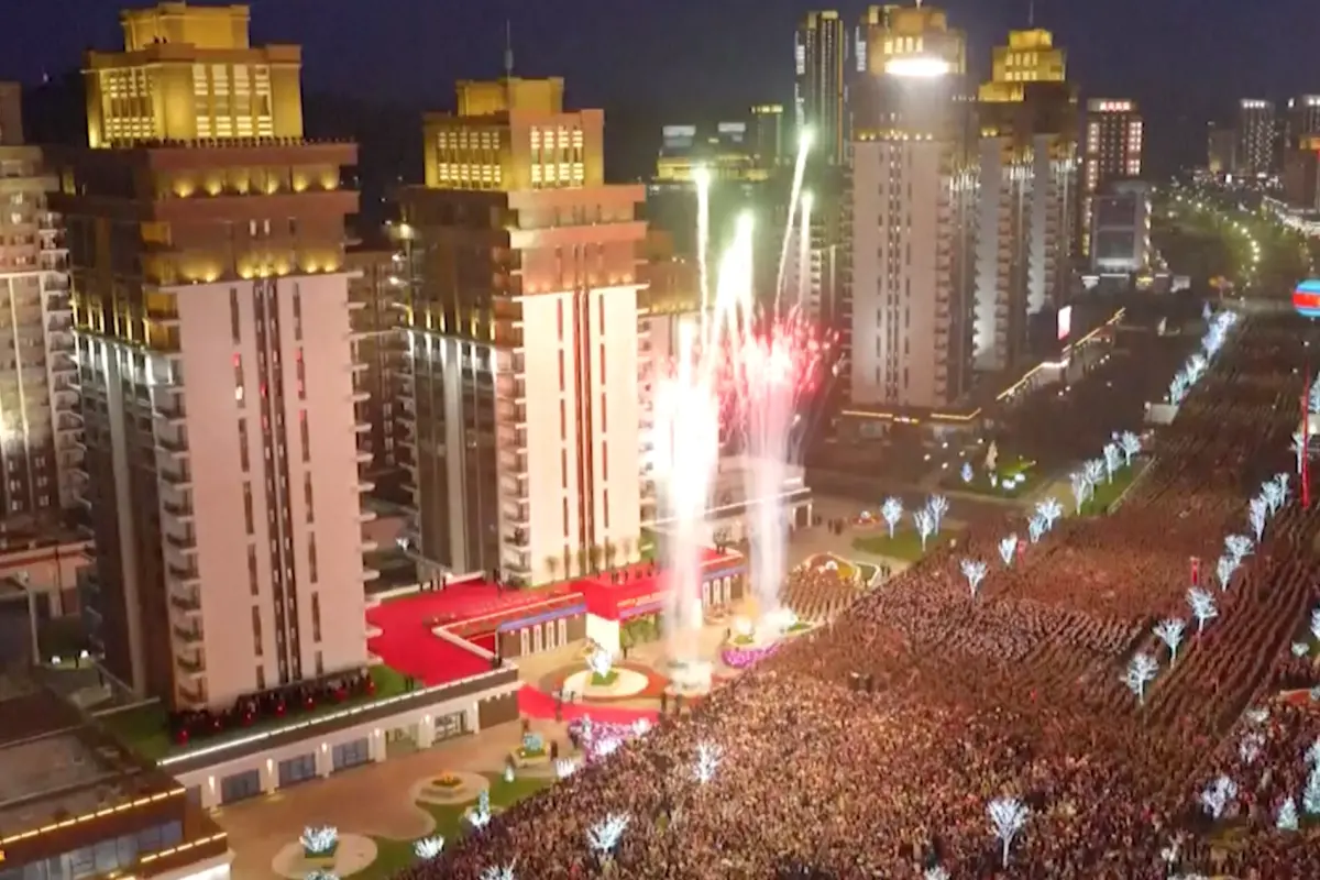 ▲北韓領導人金正恩昨（16）日出席平壤和盛地區「萬套住宅」第二期計畫竣工典禮，現場擠滿歡迎人潮，萬頭攢動，還施放煙火與飛機飛行表演，宛如嘉年華。（圖／翻攝自美聯社影片截圖）