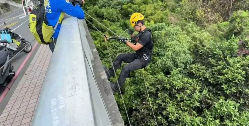 ▲高雄市鼓山區萬壽山橋傳出意外，外國民眾清晨運動目擊1名男子俯臥在20米下方的水潭中，立即報案。警消獲報到場後，利用繩索進行救援。（圖／翻攝畫面）