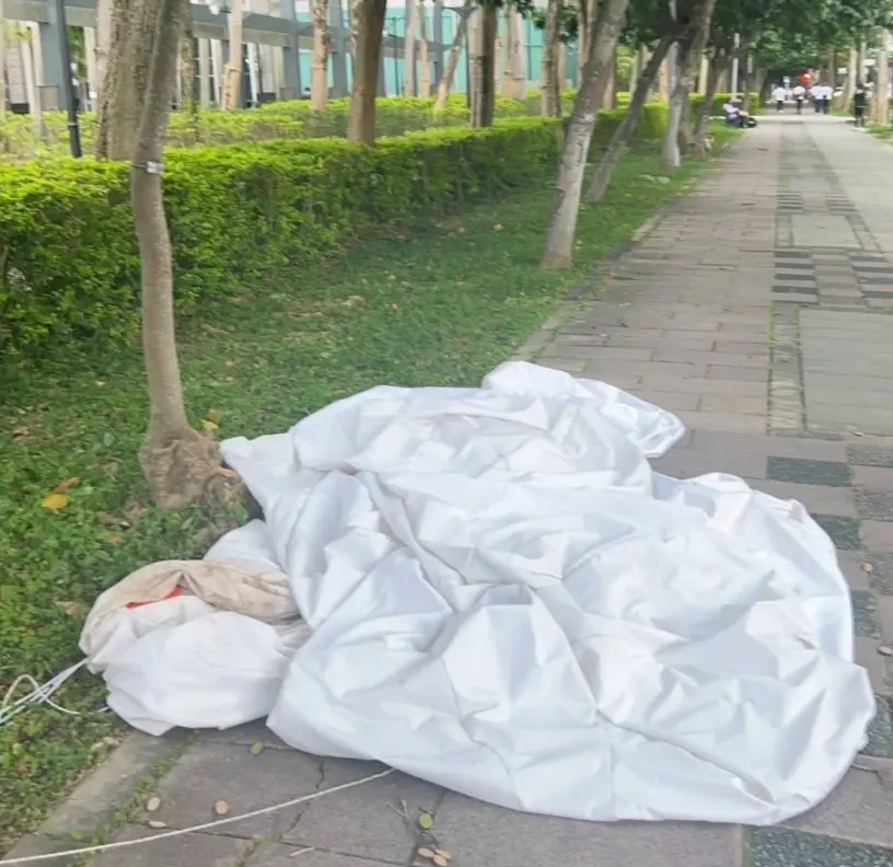 ▲信義區百貨外展出的類氣球裝置藝術被吹走，飛越50公尺衝向松仁路，恰巧砸到一名56歲謝姓男騎士，導致他當場倒地，臉頰、手肘擦挫傷。（圖／翻攝畫面）