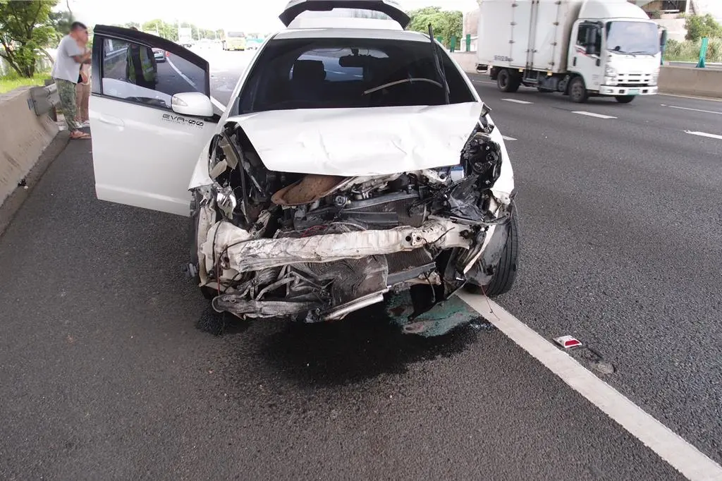 ▲一部白色HONDA轎車為了閃避掉落在路中的紗窗而猛打方向盤，不料卻造成車輛失控撞上外側護欄。（圖／翻攝畫面）