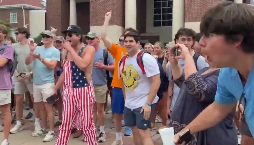 ▲美國密西西比大學挺巴示威與反示威者對抗，一名反示威者做出猴子的動作和聲音嘲諷一名非裔女子，事件引發白宮關注。（圖／翻攝自Ｘ）