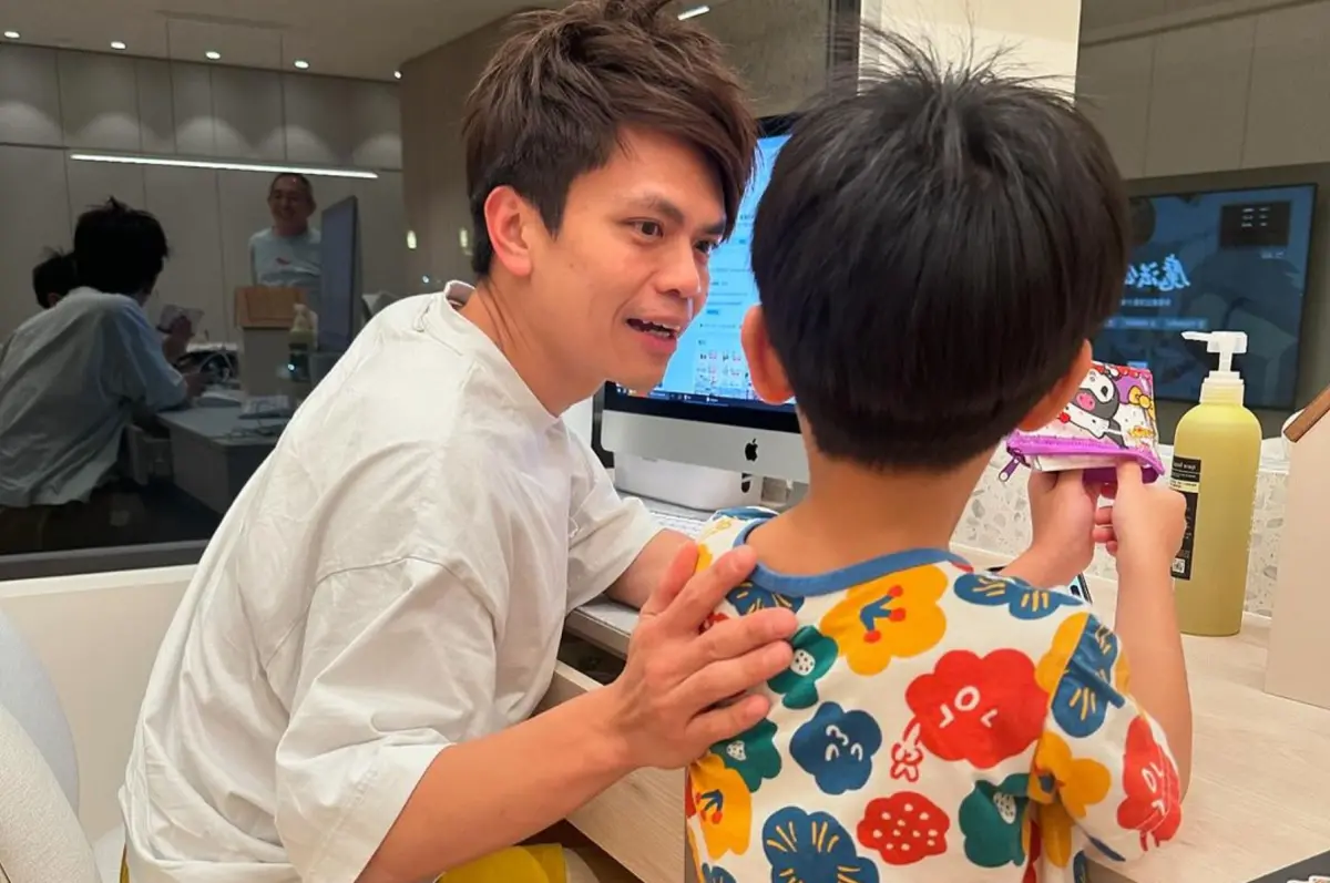 ▲蔡阿嘎被兒子問最喜歡什麼商品，他回答「老闆娘」展現滿滿求生欲，玻璃反射出岳父站在後面。（圖／二伯IG）