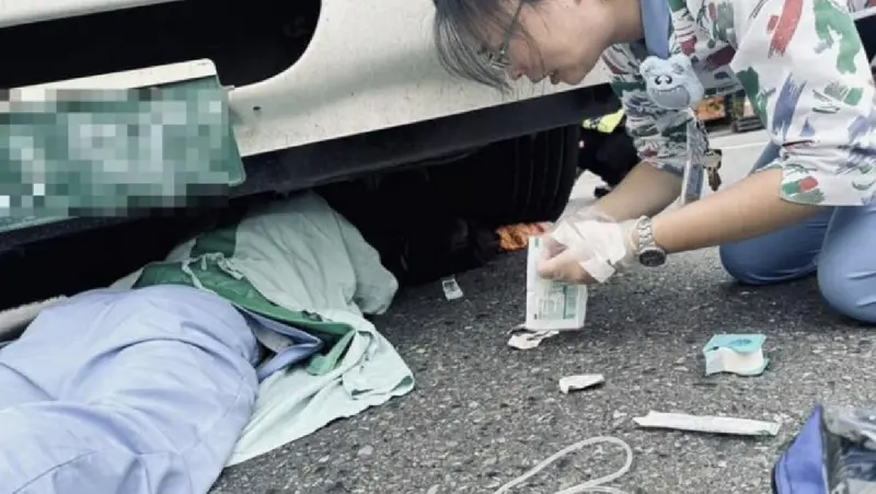 ▲南投謝姓婦人因車禍遭捲進輪下，秀傳醫院急診室醫護緊急到場，趴在地上為受困的謝婦打點滴，照片感動了許多網友。（圖／翻攝ICU醫師陳志金臉書）