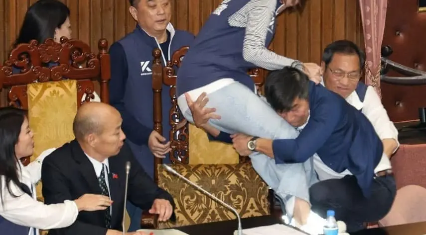 ▲鍾佳濱突襲式衝上主席台，擒抱國民黨立委陳菁徽，（圖／徐巧芯臉書）