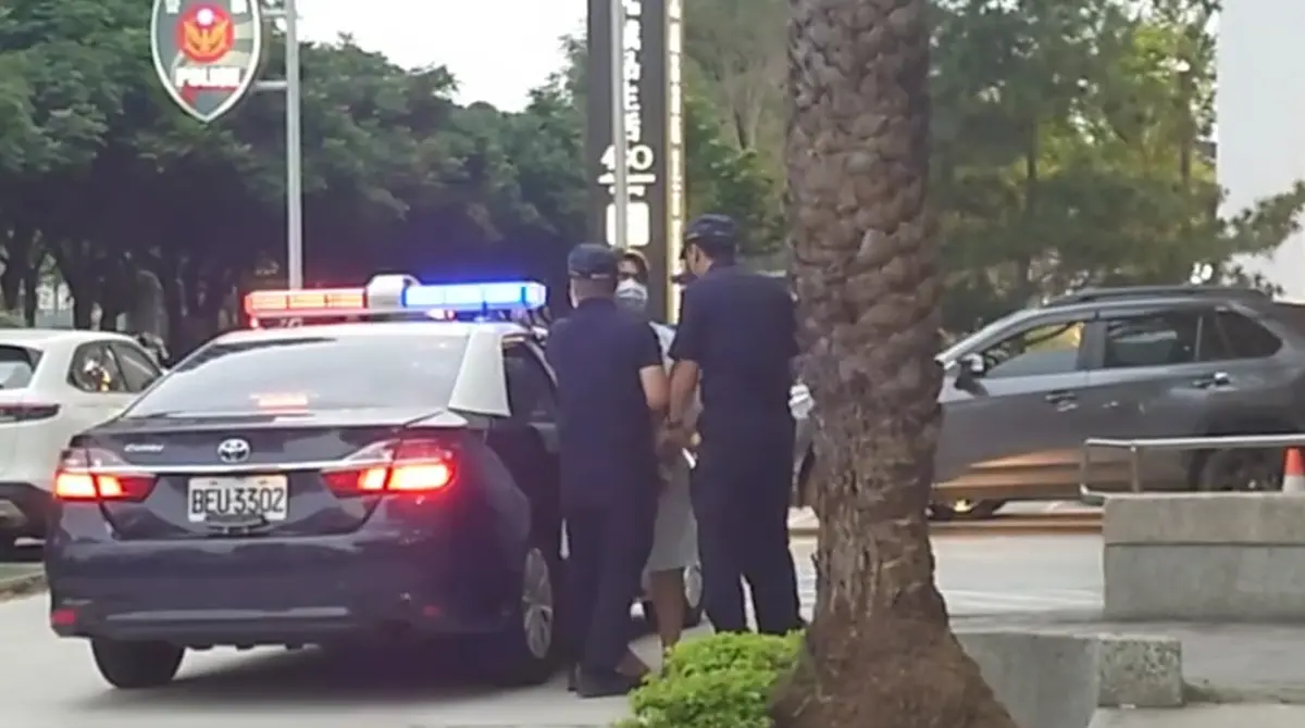 ▲洪姓男子砍傷2人後隨即遭逮捕，今天下午在警員護送下抵達分局。（圖／翻攝畫面）