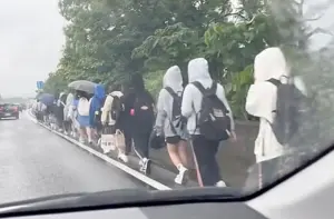國道驚見「學生排隊淋雨」!30多人背書包走路肩北上 駕駛全傻眼