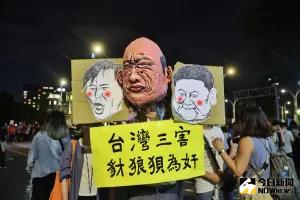 ▲周邊抗議人潮中，有人手持「台灣三害」標語，諷刺韓國瑜、傅崐萁、黃國昌。（圖／記者陳明中攝）