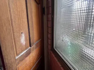 ▲子彈擊破一旁民宅窗戶及木門。（圖／翻攝畫面）
