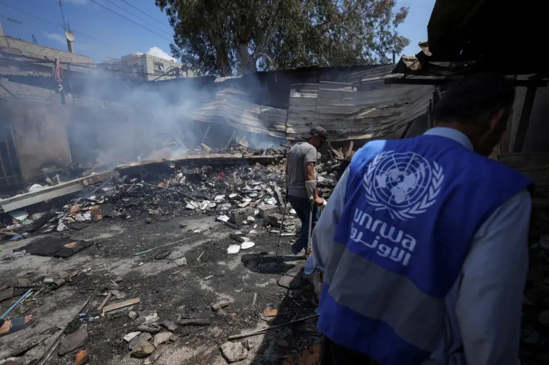 ▲以色列國會正在審議一項爭議性法案，欲切斷與聯合國「近東巴勒斯坦難民救濟和工程處」（UNRWA）的聯繫，將UNRWA定性為「恐怖組織」。圖為身穿UNRWA背心的工作人員在加薩空襲現場。（圖／美聯社／達志影像）
