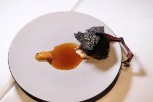 「嘉義鵪鶉/金棗/腐乳」這道菜中,黑色脆片下是香嫩多汁的烤鵪鶉。(圖/記者葉盛耀攝) ▲「嘉義鵪鶉/金棗/腐乳」這道菜中,黑色脆片下是香嫩多汁的烤鵪鶉。(圖/記者葉盛耀攝)