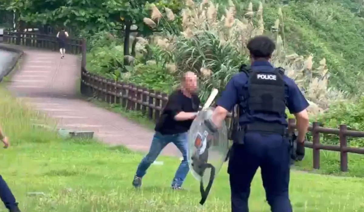 ▲基隆外木山一名38歲的葉姓男子情緒激動持一把長刀，在停車場與警方對峙。（圖／翻攝畫面）