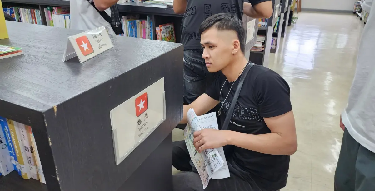 ▲新二代發起教越籍移工華語的計劃。圖為找書借閱的外籍移工。（圖／移民署提供）