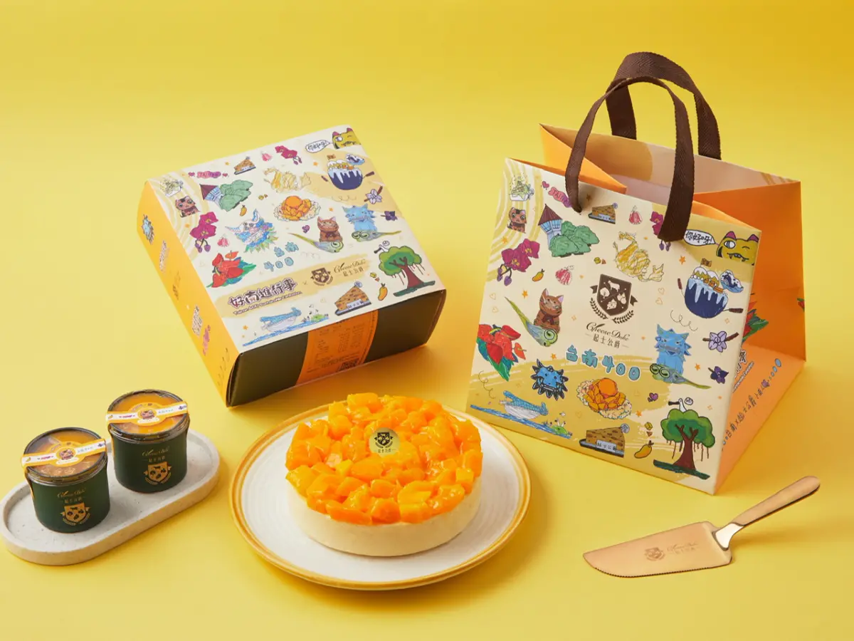 ▲可愛童趣有著臺南與芒果意象的手繪插畫出現在起士公爵2024夏日限定款「夏日派對芒果乳酪蛋糕」的包裝上。（圖／起士公爵提供）