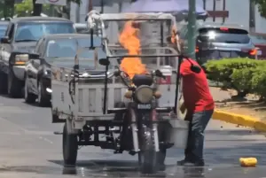 ▲機車車頭燃起熊熊烈火，嚇得駕駛立刻下車，找一旁商家拿水桶來撲滅火勢。（圖／翻攝X@THE_GLOBE_N）